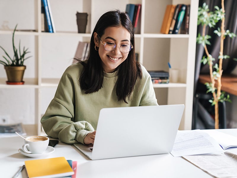 menina mexendo no computador e sorrindo