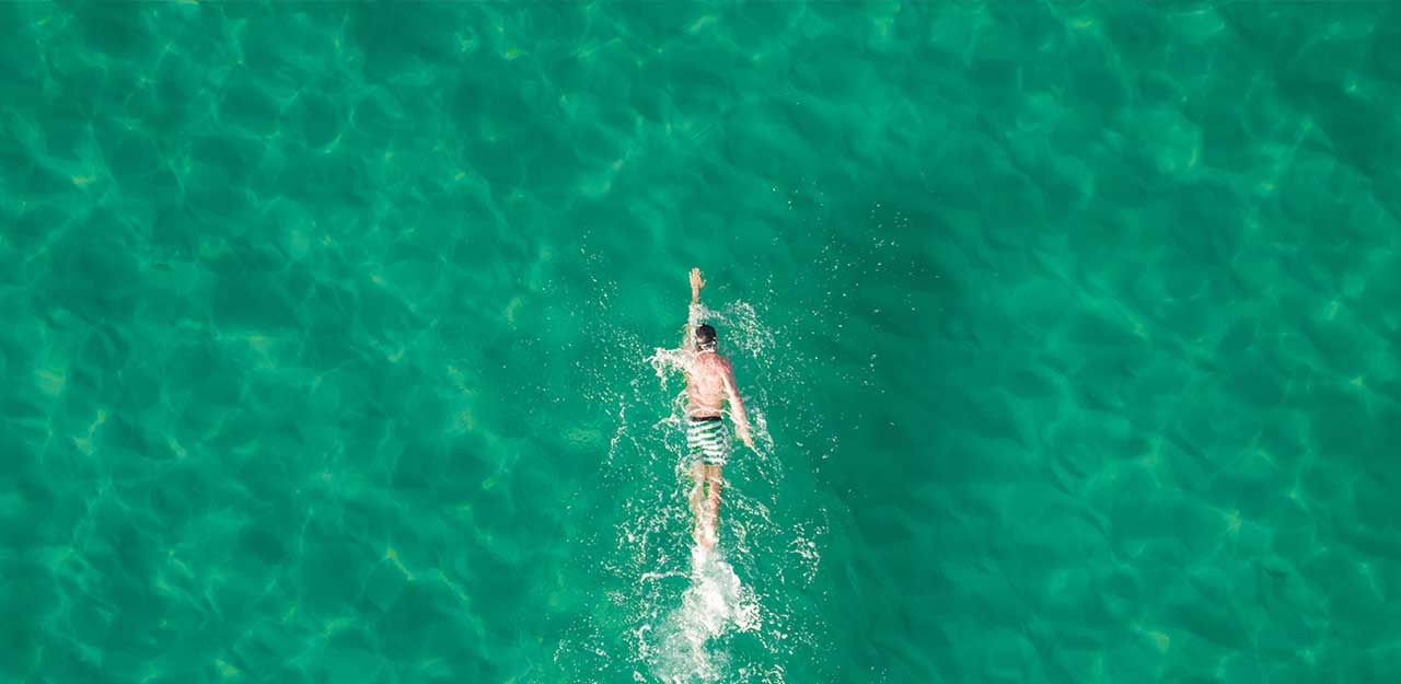 homem nadando no mar, visto de cima