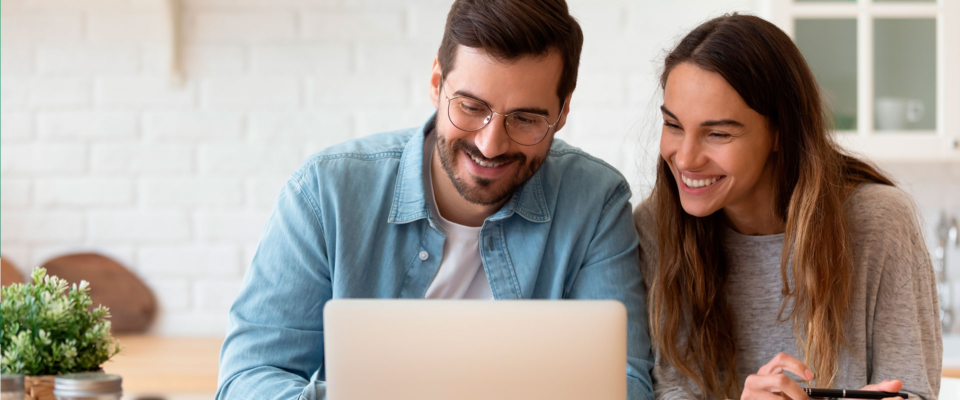 homem e mulher olhando para o computador e sorrindo